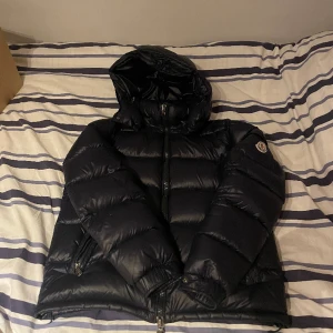 Moncler Maya Navy - En moncler maya navy i bra skick Size 3, qr kod, cartoon och nfc scan.  Har 2 revor (bild finns) Därav billiga priset.