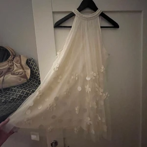 Studentklänning - Vit klänning med söta blomdetaljer, helt perfekt till dig som tar studenten till sommaren💕 