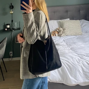 Väska - Säljer denna fina, praktiska väska från h&m! Det är mockatyg utanpå och skinn i botten. Endast ett stort rymligt fack, som du kan knyta igen. Får plats med väldigt mycket i den🖤