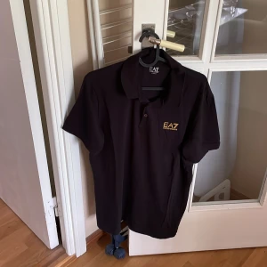 Pikétröja: EA7 (Emporio Armani) - Storlek XL (sitter som L). Säljes, i samband med för liten storlek. Sparsamt använd, i nytt skick så gott som oanvänd.   Pris: 150kr