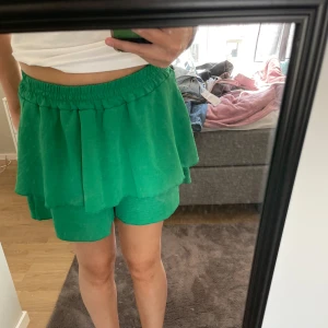 Grön volang kjol!  - Grön kjol med volanger och shorts under! Köpt i en butik utomlands så vet ej storlek men skulle gissa på S, har även lagt ut en matchande topp om man vill köpa som sett!! Använd ca 2 gånger så inga defekter 