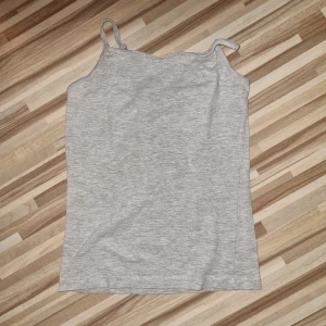 Grå linnetopp - En enkel och stilren grå linnetopp med smala axelband. Toppen är ärmlös och har en rak passform.