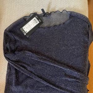 Mesh festtopp - Marinblå glittrig topp i mesh från Vero Moda. Helt oanvänd med prislappen kvar. Storlek M men passar mig bra som vanligtvis har S.