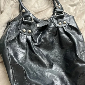 Skinn väska svart - Väskan är lite sliten och gammal men den är funktionärlig. Vet inte om det är riktigt skinn men tror inte det. Pris 200kr (går att önska annat pris)