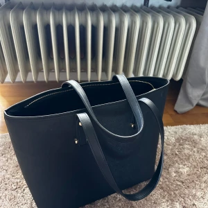 svart väska - snygg stor rymlig svart väska från h&m, använd men inga skavanker alls!