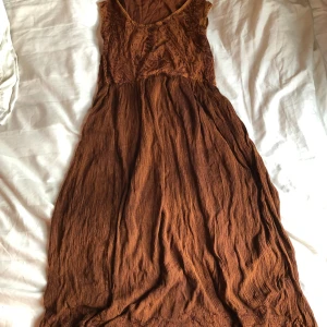 Klänning💓 - En brun midi klänning från märket Coline. Den har knyte där bak och superfina mönster vid bysten och längst ner på klänningen. Står ingen storlek men skulle gissa S till XS. Den är i bra skick!💓✨Skriv om du vill ha fler bilder eller vill fråga något🫶