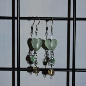 Örhängen  - Handgjorda örhängen med gröna hjärtan. De görs vid beställning och är därmed helt oanvända. Krokarna är gjord av äkta silver. Kolla gärna in min profil för fler handgjorda örhängen :)) 