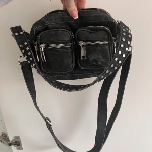 Noella - Glittrig Noella väska. Har färgfläckar som går av vid tvätt. 150kr