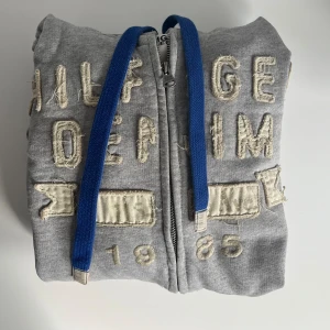 Tommy Hilfiger hoddie  - Ljusgrå hoddie från Tommy Hilfiger i mycket bra skick. Hängd i garderoben. Kan även  användas som jacka få den har dragkedja. Storlek S.