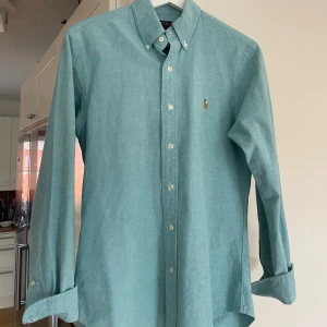 Ralph Lauren Skjorta | Blå/Grön | - Säljer en oanvänd Slim Fit Ralph Lauren skjorta till ett bra pris. Skjortan är i storlek S och borde passa om man är runt 165-185 cm beroende på hur man vill att den ska sitta. Pris kan diskuteras.