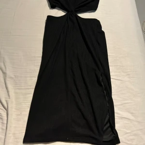 Svart klänning - Svart klänning med slits på ena sidan Strl. XL Aldrig använd
