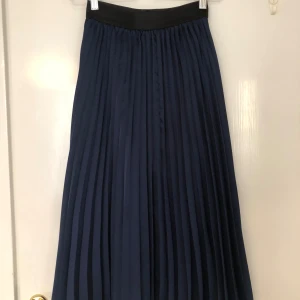 Marinblå midi kjol - Marinblå midikjol från Bershka. Lite slitage (se bild) men i helhet i mycket bra skick.