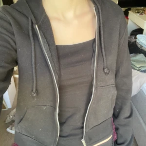 Svart zip-hoodie  - Säljer en lite kortare svart zip-hoodie från H&m divided i strl. S💗Använd ca 7 gånger och har inga fel!! Perfekt basplagg/basic och på sommarkvällar☺️Billiga kläder➡️min profil❤️