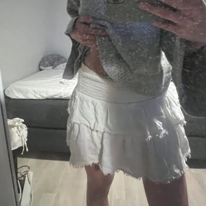 Vit kjol - Säljer denna snygga volang kjol som är i kortare format. Köpt i canada för cirka 600kr men använd få gånger och är i fläck fri. Hör av dig om du har några funderingar 