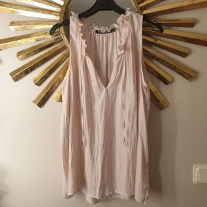 Topp - Ljusrosa topp i storlek L, vet inte varför det står 44/46 men den är en som en large. 