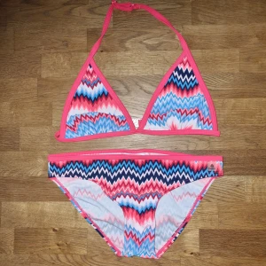 Mönstrad bikini från Firefly - En färgglad bikini från Firefly med ett zigzag-mönster i rosa, blått, vitt och svart. Bikinin har en trekantsöverdel med knytband och en matchande underdel. 