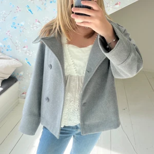 Grå kappa - En stilren jätte snygg grå kappa, fläcken är på spegeln och inte jackan, väldigt sällan använd så jätte fint skick!!🥰