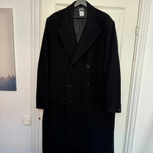 Hope ullrock - Dubbelknäppt ullrock från svenska Hope. Tidslös och väldigt stilig. Får en att se ut som en filmstjärna.   Varsamt använd, litet hål inuti den vänstra ytterfickan, annars felfri. 