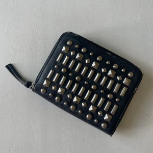 Svart plånbok med nitar - Otroligt fin plånbok med nitar, älskar verkligen denna men tyvärr kommer den inte till användning, den har defekter som syns på bilderna