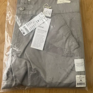 Low waist cargo - Ny oanvänd snygg Low waist cargo byxa i ljusgrå, i oöppnad påse. Stl. 38. Ginatricot. Nypris 499kr.