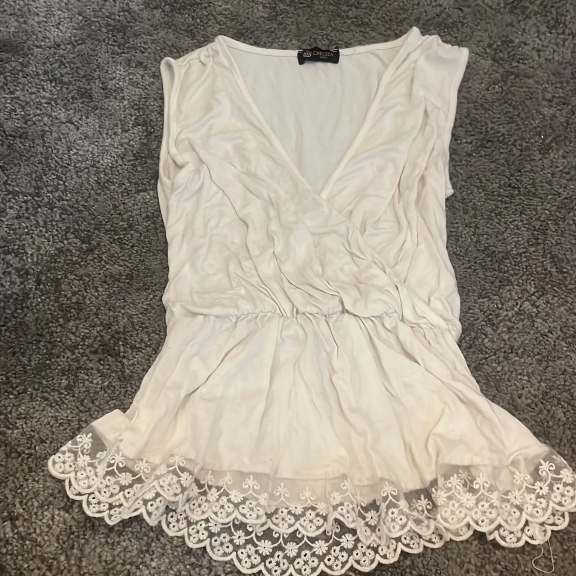 En blus/linne med genom skinligt spets längst ner