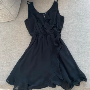 Svart klännig  - Söt svart klännig med volanger 