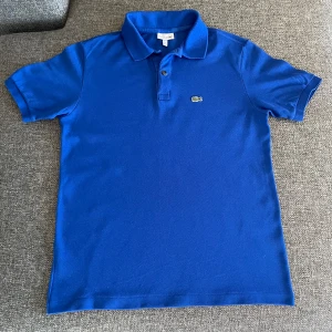 Lacoste - Blå Lacoste piké i dunder skick fett nice att ha på sig 