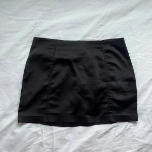 Minikjol i satin - Supersnygg svart minikjol i satin från Gina tricot. Endast använd ett fåtal gånger så i bra skick! Har en dragkedja i bak. 