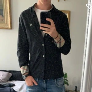 Burberry skjorta  - Säljer nu denna överfeta burberry skjorta som är köpt av vinofino här på plick. Den är i begagnat skick och har tyvärr tappat en knapp, dock inget man märker vid användning. Annars fint skick:) Size s