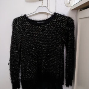 En fluffig tröja - En svart fluffig tröja med guld söm från Definitions i storlek M 120kr