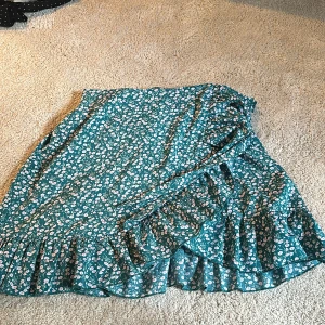 Grön möstrad omlottkjol  - Kjolen är knappt använd är i fint är omlott och går lite ovanför knäna. 