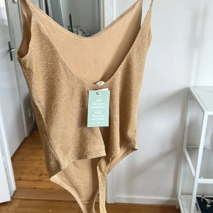 Glittrig guld body - Oanvänd, storlek S 