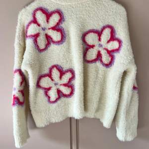 Lurvig krämvit tröja med blommor i rosa och lila. Kommer ursprungligen från Bershka och är i stl xs oversized fit. Sparsamt använd i fint skick. Använd ”köp nu” om du vill köpa🌸