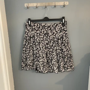 Kort kjol  - Jätte söt somrig kjol, grå/svart blommigt mönster, står ingen strl men skulle säga S/M, finns en svart underkjol, aldrig använd✨✨