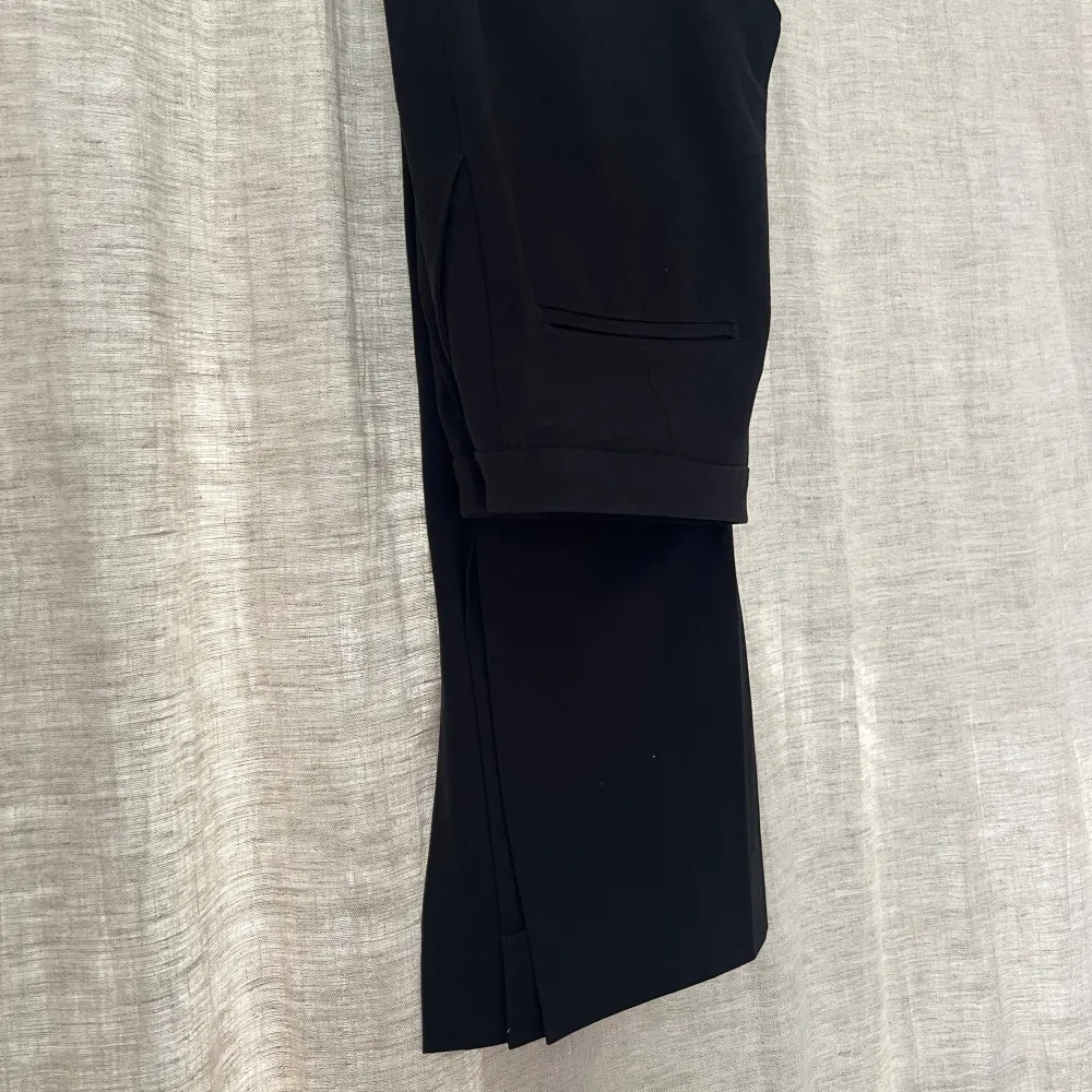 Svarta kostymbyxor i storleken 36 från HM med slits vid slutet av byxbenet. Jeans & Byxor.