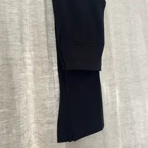 Svarta kostymbyxor i storleken 36 från HM med slits vid slutet av byxbenet