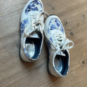 MICHAEL KORS Women's "Allie" White & Blue Florals Trainer Sneakers - Jättefina MICHAEL KORS sneakers med silver detaljer. 