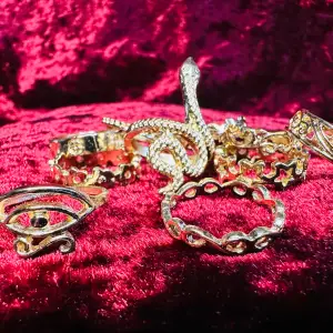 Elva nya vackra matchande guldfärgade ringar.   Vintagelook, utsirade, en Horus öga, en slingrande orm.   Har olika storlekar för att passa olika fingrar, 1,6-1,9 cm i innerdiameter.   Säljs som ett set.   Gulmetall. Färdigprutade.