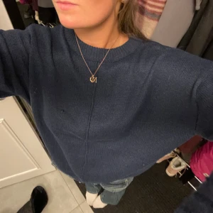 Mörkblå stickad  - Säljer denna mörkblå stickade tröjan med ett coolt sträck på framsidan, tröjan ser helt vanlig ut bak