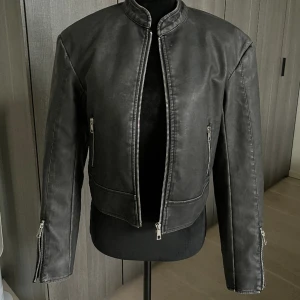 Bikerjacka i ”vintage” - Biker jacka från Nelly i strl 32. Jackan är till för att se vintage ut och är i sin modell lite croppad. Använd endast 2 ggr. Säljes för 599kr ❤️❤️❤️❤️❤️