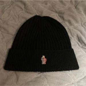Moncler Grenoble  - Hej!   Säljer nu denna fantastiska samt varma Moncler Grenoble mössan, den är i färgen svart, perfekt skick, ägt den sen december i fjol men endast använt den ett fåtal gånger.   Hör gärna av dig vid fler frågor! 👍