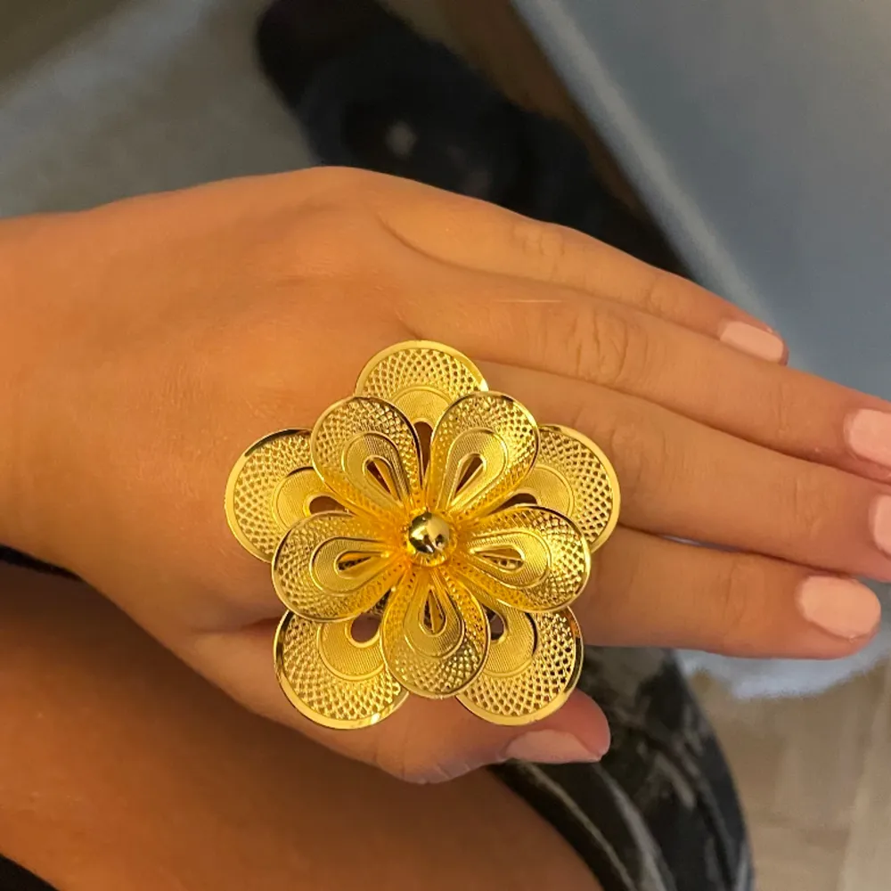 Guld ring med en stor blomma. Snyggt statement smycke! Aldrig använd . Accessoarer.