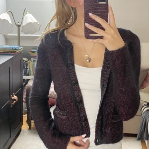 Svartröd stickad kofta - En svartröd stickad kofta med små fickor framtill 