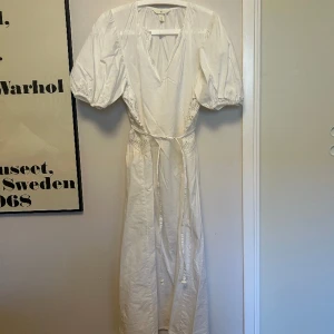 Vit klänning med brodyr - Från H&M, storlek S.  Fint skick. Knyts i midjan. 