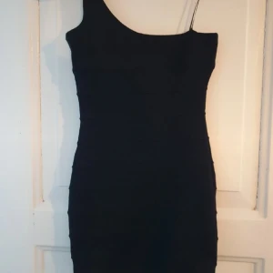 Klänning med tajt passform  - Dragkedja bak, ett axelband.