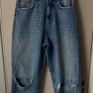 Håliga jeans - Storleken på jeansen är 38 fast har blivit sydda ihopp en bit för att kunna passa bättre, den har hål vid knäna och är från gina tricot