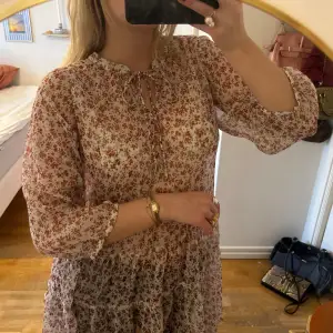 Blommig lång blus med ballongärm och knytning i halsen 🌷