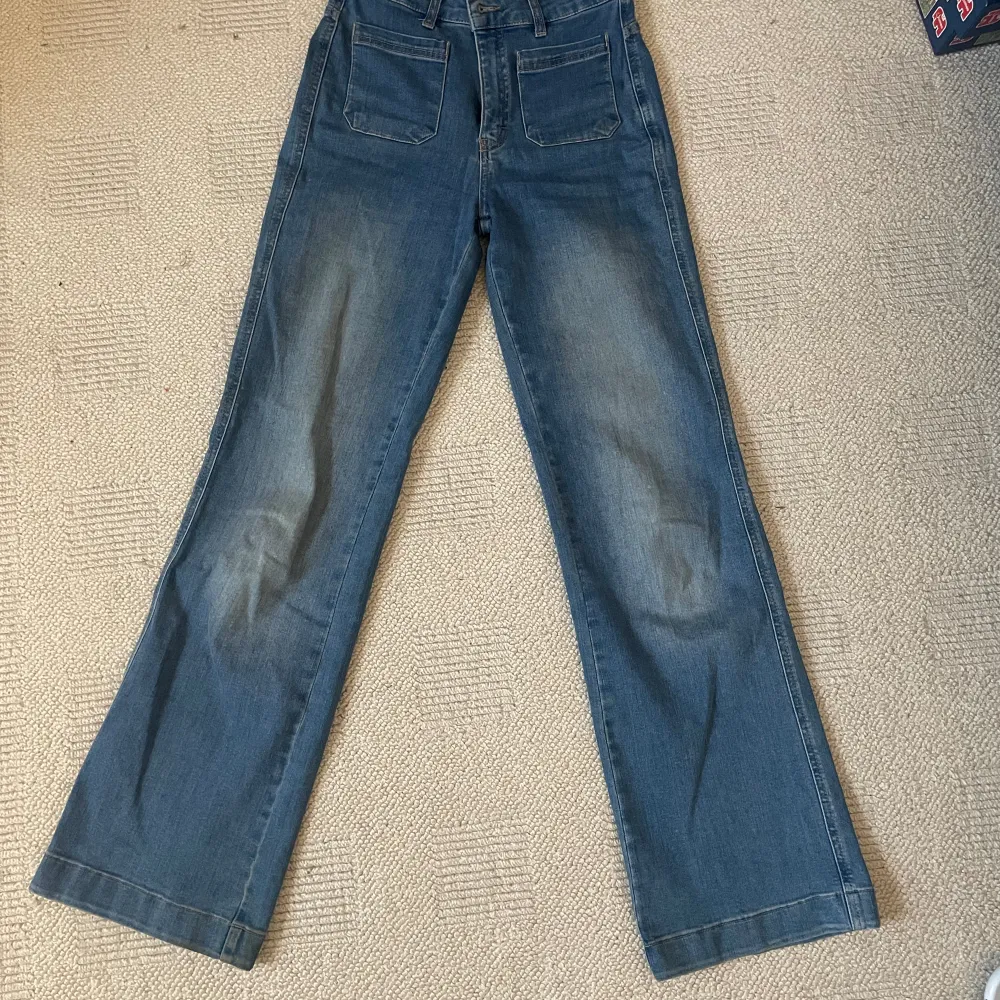 Ett par stretchiga, flared jeans med snygga framfickor. De är mid rise och sitter tajt över låren men löst runt vaderna. De är sparsamt använda utan defekter och säljer för att de är för korta för mig 🫶 . Jeans & Byxor.