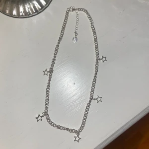 Kedjehalsband med stjärnor  - Ett jättefint halsband med stjärnor. Aldrig använt. PRIS KAN DISKUTERAS!