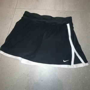 Nike Tenniskjol - Svart tenniskjol från Nike med vita detaljer, integrerade shorts på insidan, storlek XS 🫶🏼